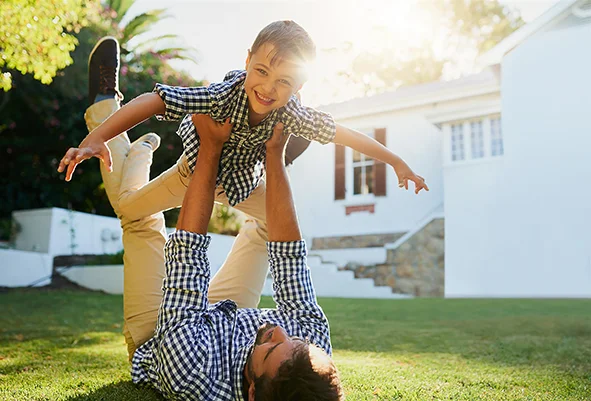 Father and son playing outside in backyard