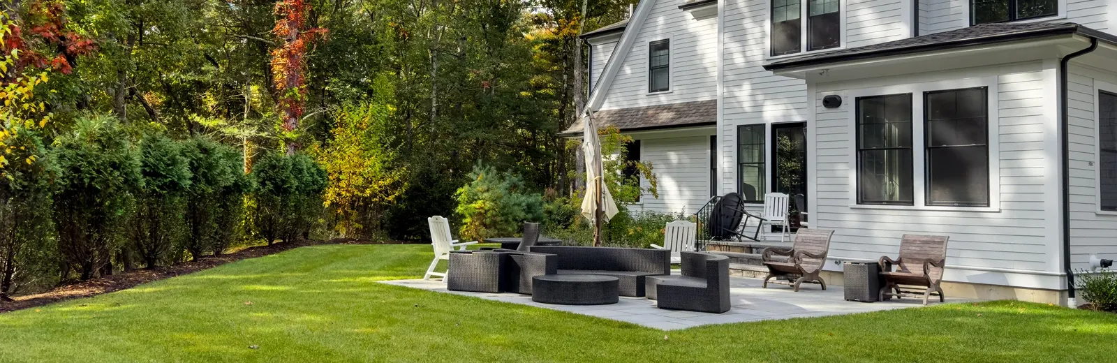 white house with nice backyard patio and landscaping