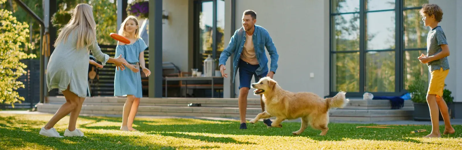 family playing in backyard with dog